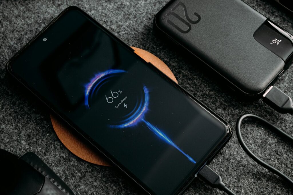 Reliable Portable Power Setup — travel essentials for women Smartphone charging on a wireless charger with a portable power bank connected — travel essentials for women