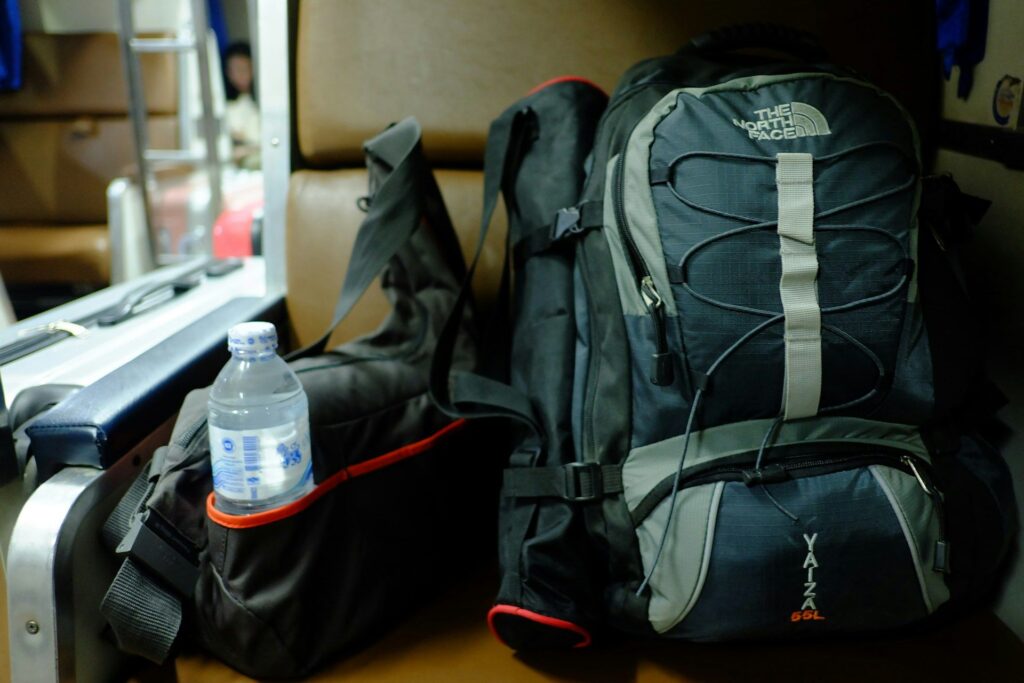 Travel Essentials: Reusable Water Bottle — long flight comfort essentials Reusable water bottle next to travel backpacks on a seat — long flight comfort essentials