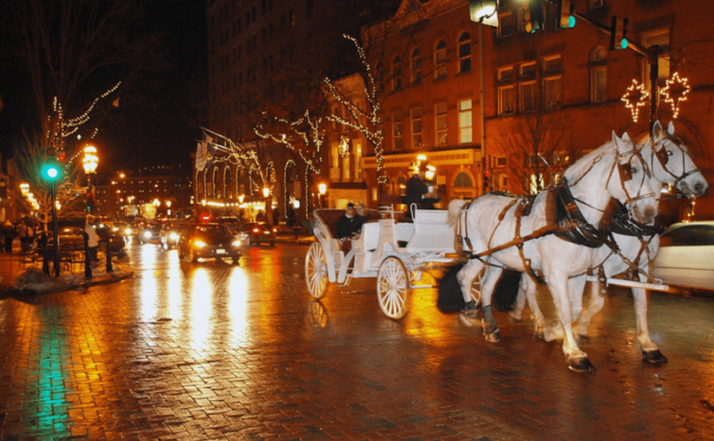 Bethlehem Christmas Town — Christmas towns in the USA Horse-drawn carriage in a festive town street with holiday lights — Christmas towns in the USA
