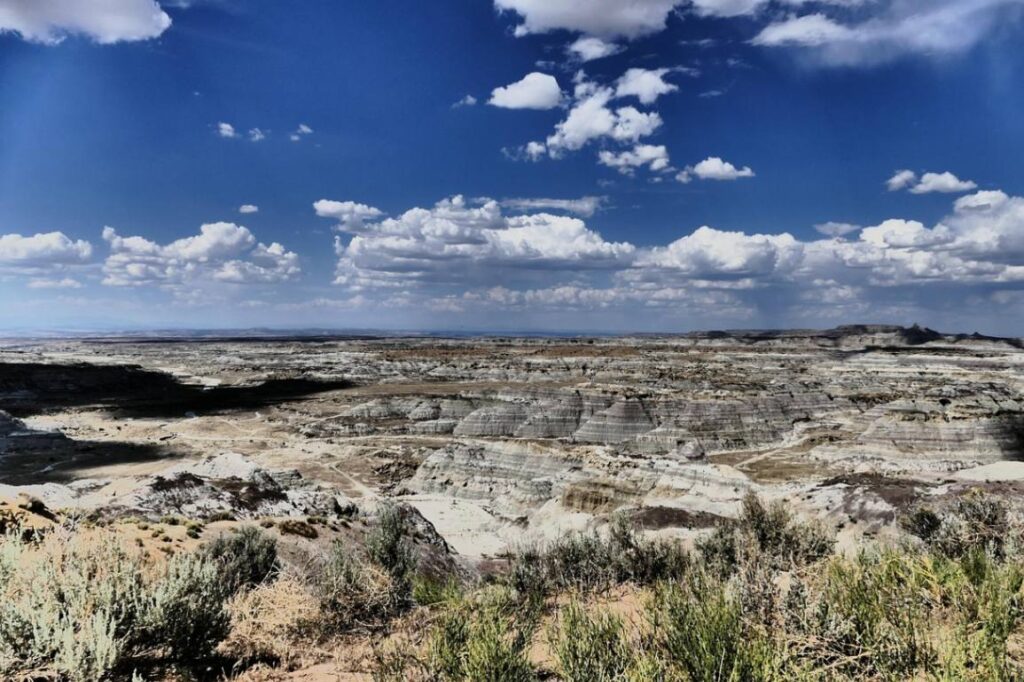 Bisti/De-Na-Zin Wilderness Landscape — secret places in the USA Bisti/De-Na-Zin Wilderness landscape with layered rock formations and cloudy sky, showcasing a — secret places in the USA