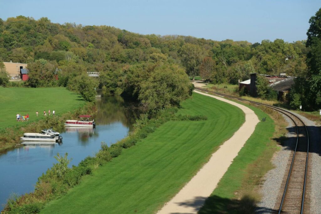 Charming Small Town River View — charming small towns in the USA Scenic view of a river and green landscape with walking paths and trees in a small town. — charming small towns in the USA