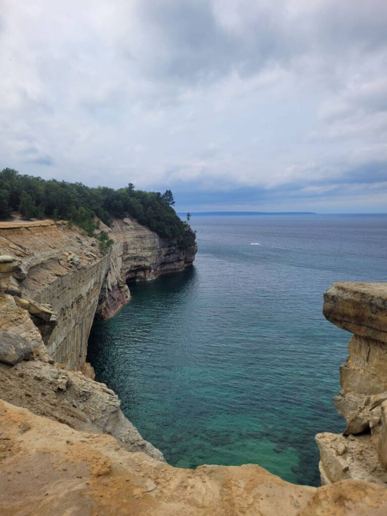 Cliffs by the Sea — secret places in the USA Cliffs overlooking a calm blue sea with green trees along the shoreline, representing hidden gems — secret places in the USA