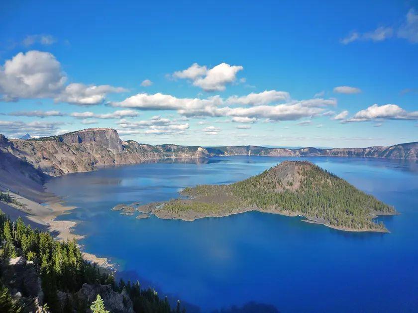 Crater Lake View — unique travel destinations in the USA Crater Lake with a small island surrounded by blue water and green trees under a — unique travel destinations in the USA