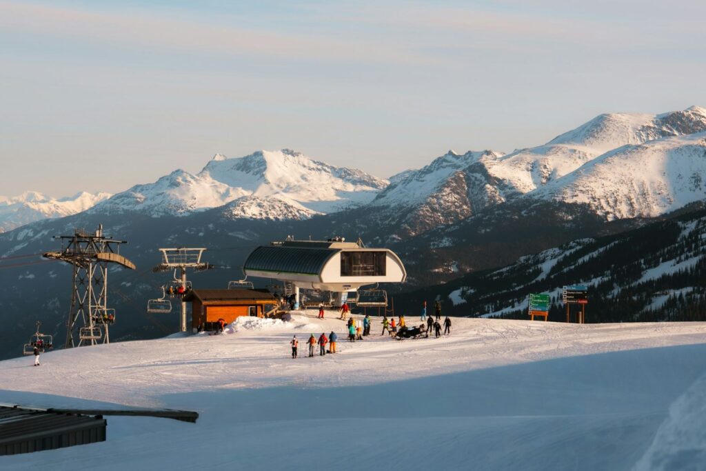 Ski Resort and Snowy Mountains — ski trip packing list Ski resort with snow-covered mountains and skiers near a ski lift. — ski trip packing list