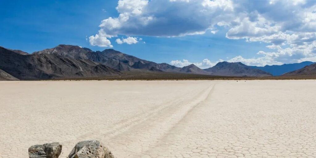 Death Valley National Park Landscape — unique travel destinations in the USA Dry, cracked earth and distant mountains in Death Valley National Park, California. — unique travel destinations in the USA