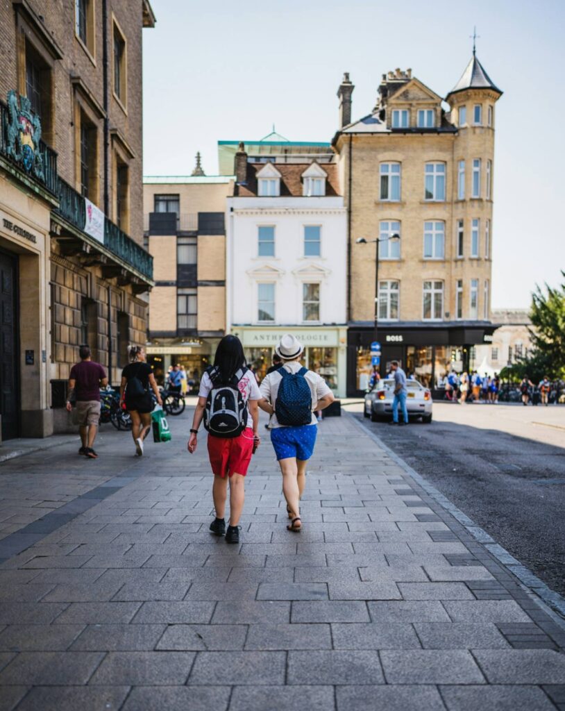 Travelers Exploring a City — international travel tips for first-time Two travelers walking on a city street with shops and buildings in the background. — international travel tips for first-time
