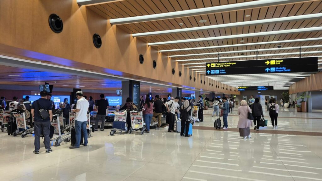 Airport Terminal Crowd — smoother airport experience Crowd of travelers with luggage carts at an airport terminal. — smoother airport experience