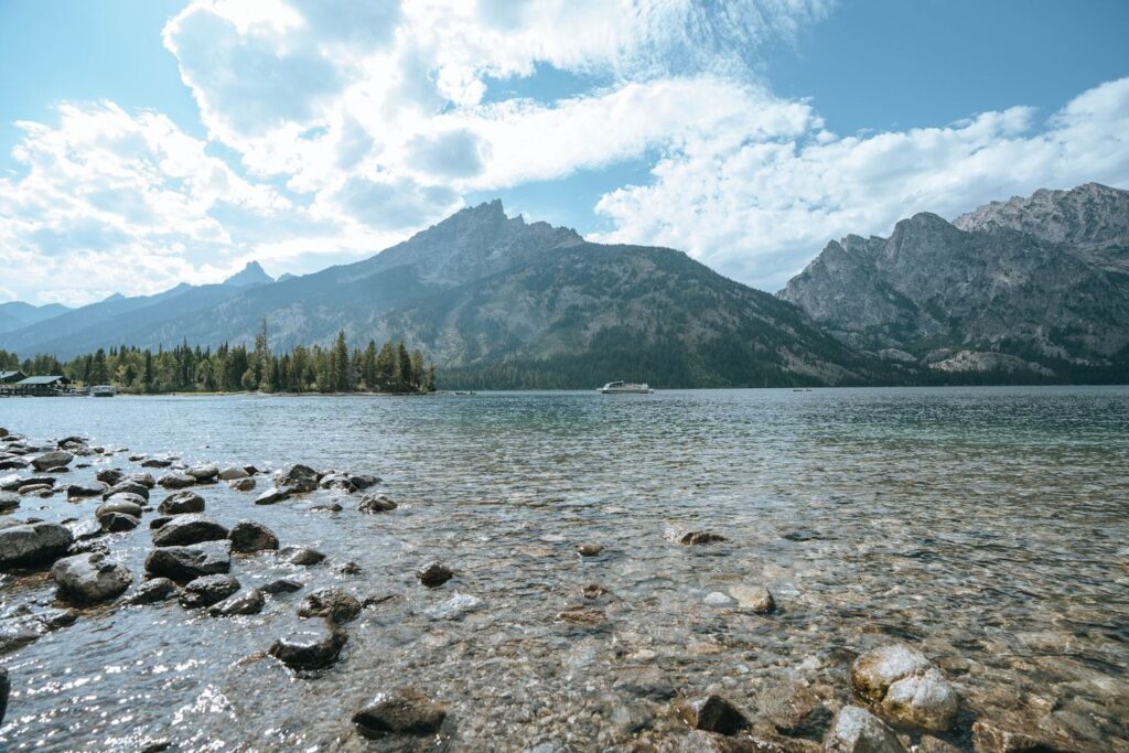 Grand Teton National Park View — Places to Visit in the Western USA Scenic view of Grand Teton National Park with clear lake water and mountain peaks under — Places to Visit in the Western USA