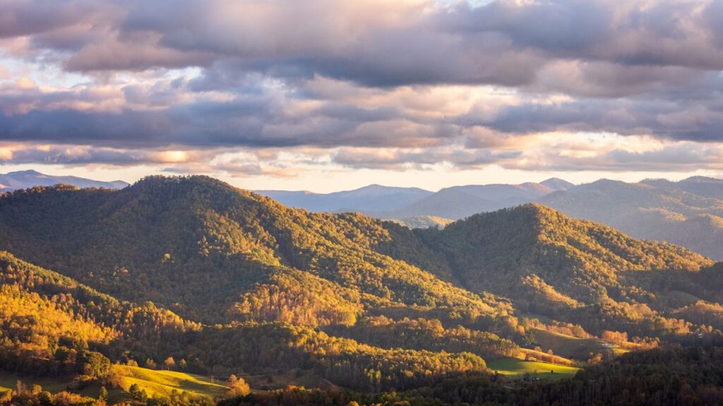 Great Smoky Mountains View — cheap places to travel in USA Great Smoky Mountains landscape with rolling hills and cloudy sky — cheap places to travel in USA
