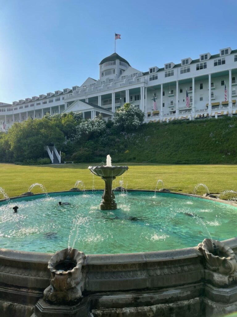 Historic Hotel Fountain in Mackinac Island — charming small towns in the USA Fountain in front of a historic hotel with American flags in Mackinac Island, Michigan. — charming small towns in the USA