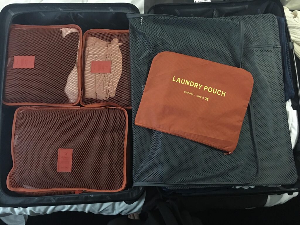 Packing Cubes for Travel Organization — carry-on packing essentials Packing cubes organized in a suitcase for travel. — carry-on packing essentials