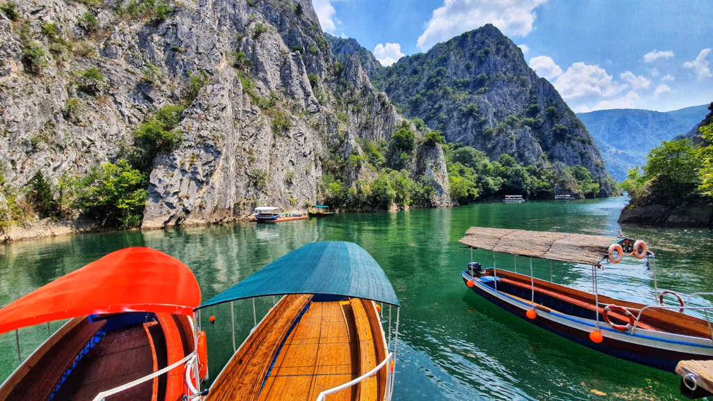 Lake Ohrid in North Macedonia — underrated countries to visit Scenic view of Lake Ohrid in North Macedonia with colorful boats and mountains. — underrated countries to visit