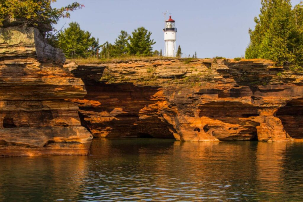 Lighthouse at Apostle Islands — secret places in the USA Lighthouse on rocky shoreline with clear water, representing hidden gems in America. — secret places in the USA