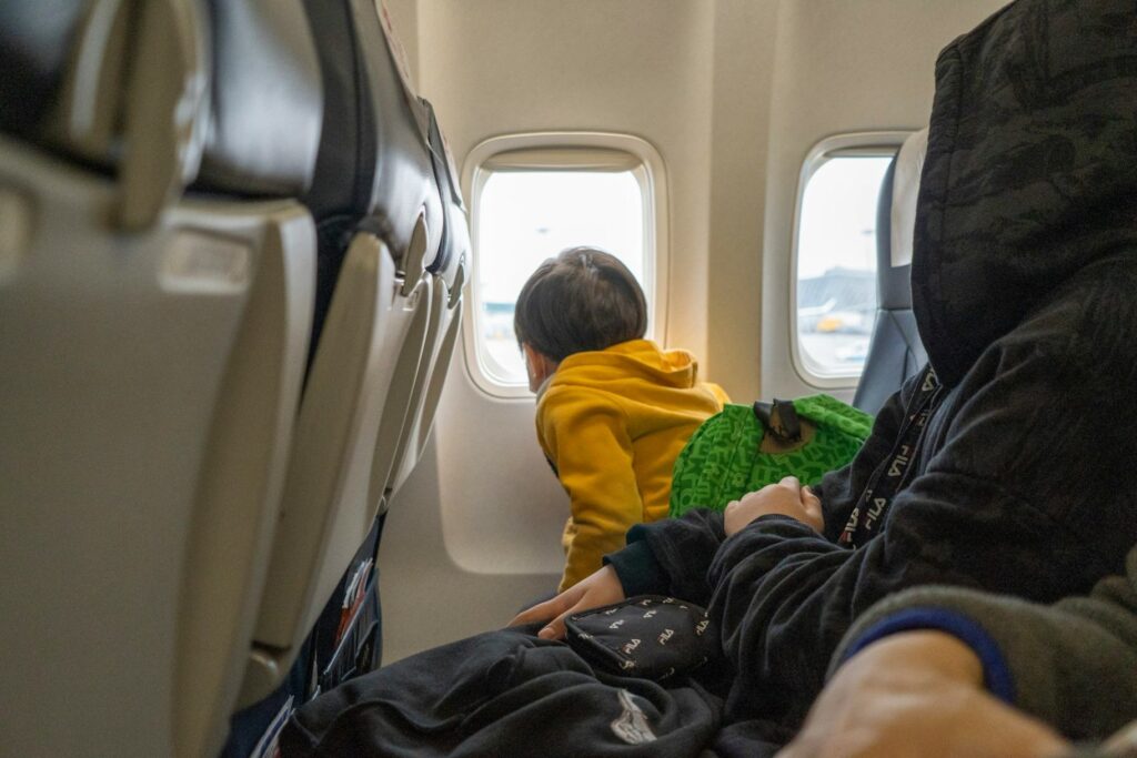 Child Enjoying Airplane View — Travel tips with kids Child looking out airplane window during travel. — Travel tips with kids
