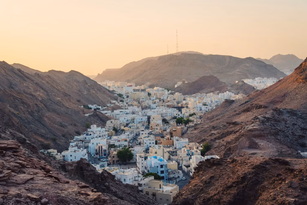 Muscat, Oman at Sunset — underrated countries to visit View of Muscat, Oman, surrounded by mountains at sunset. — underrated countries to visit