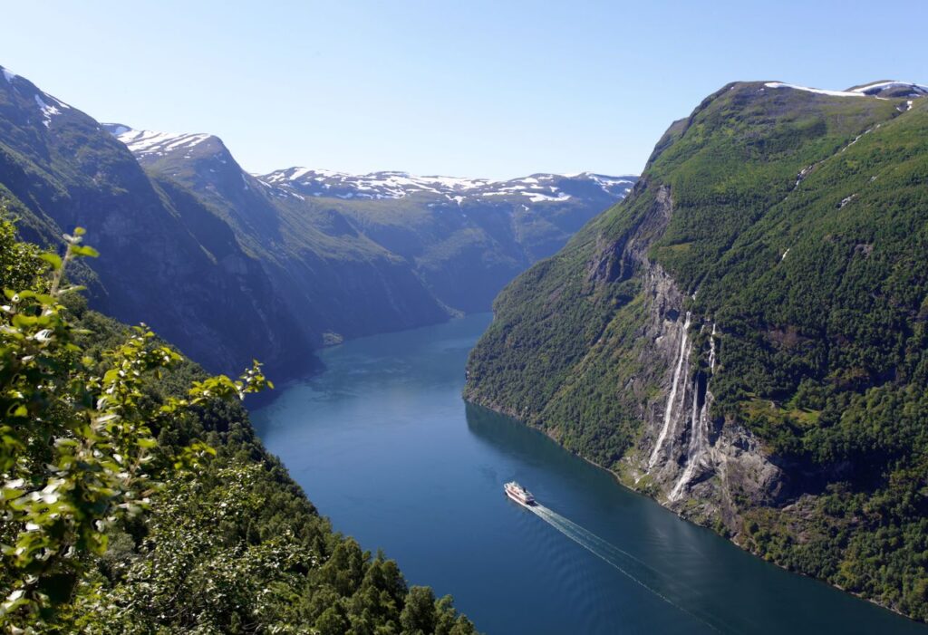 Norwegian Fjords in Norway — beautiful getaways in Europe Norwegian fjords with mountains and a waterfall — beautiful getaways in Europe