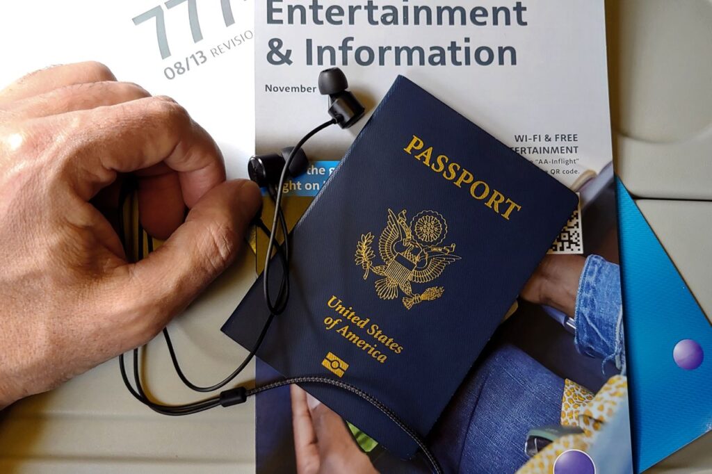 Travel Documents and Headphones — international travel tips for first-time Passport and travel documents on a table with headphones. — international travel tips for first-time