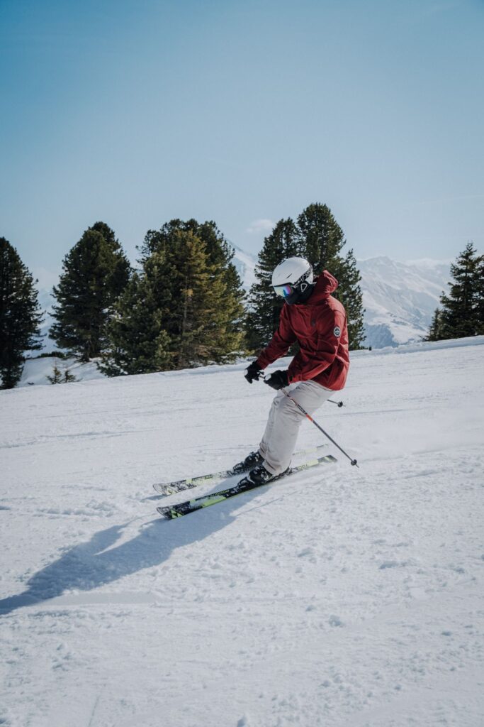 Skiing in Winter Wonderland — ski trip packing list Person skiing on a snowy slope with trees in the background — ski trip packing list
