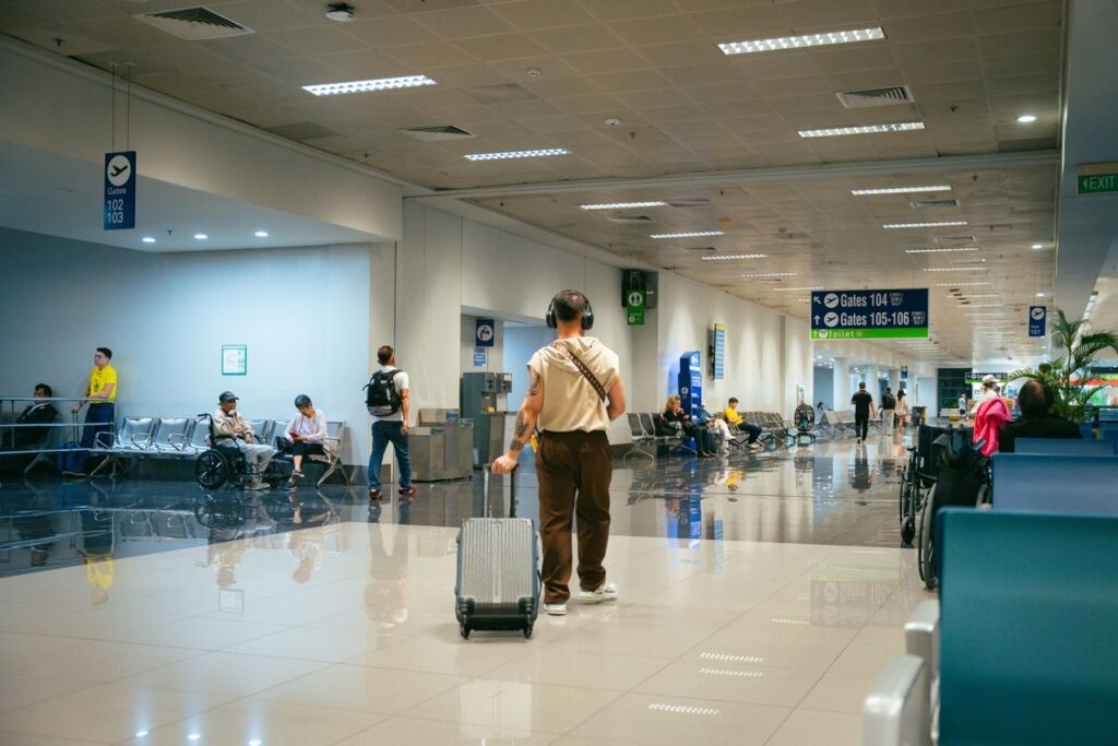 Navigating the Airport Terminal — smoother airport experience Traveler navigating the airport terminal with a suitcase — smoother airport experience
