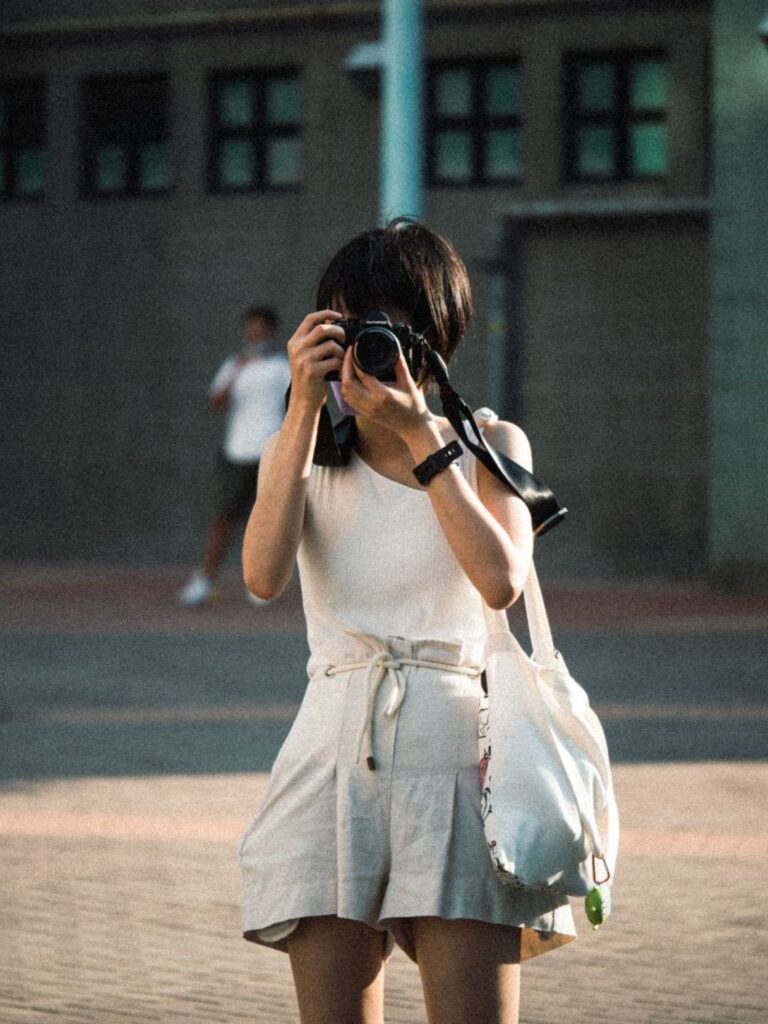 Solo Female Traveler with Camera — 8 solo female travel ideas A solo female traveler taking a photo with a camera in an urban setting. — 8 solo female travel ideas