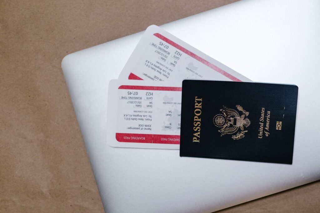 Travel Documents for Your Checklist — travel essentials checklist Travel documents including a passport and boarding passes on a laptop. — travel essentials checklist