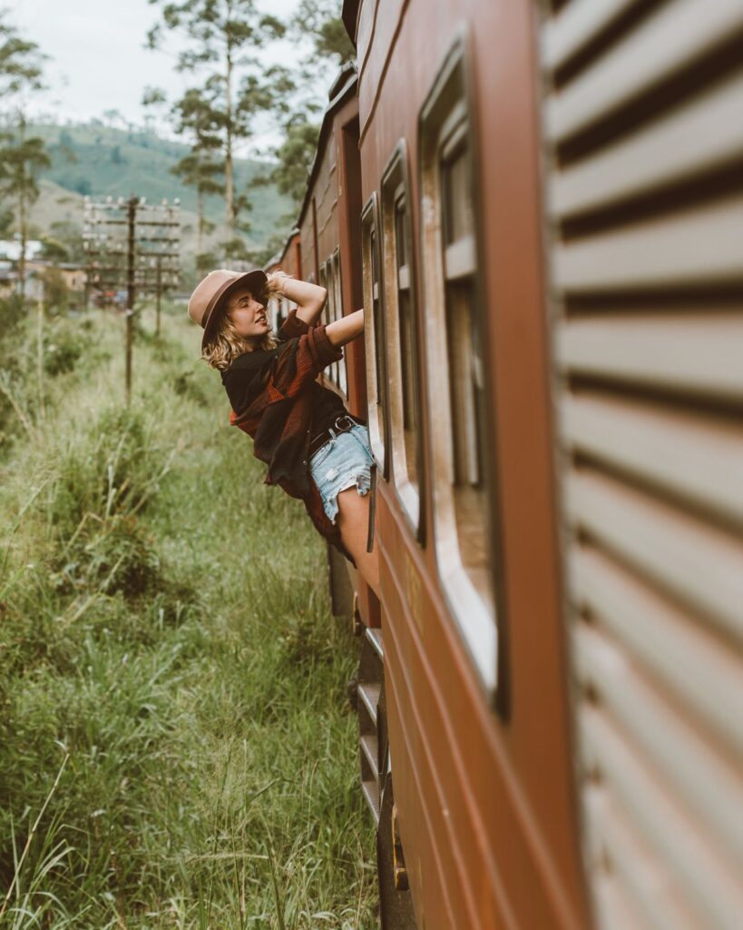 Scenic Train Journey — 8 solo female travel ideas A solo female traveler enjoying a scenic train journey through lush greenery. — 8 solo female travel ideas