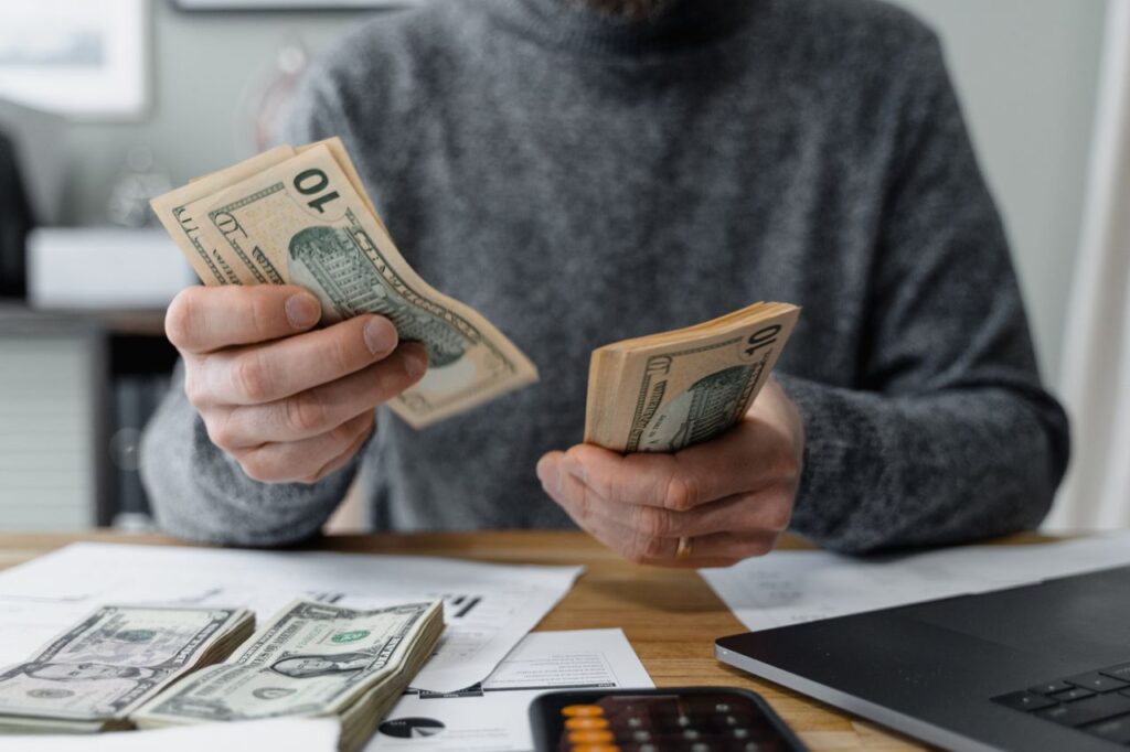 Budget Travel Planning — Budget Travel Tips Person counting cash for budget travel planning — Budget Travel Tips