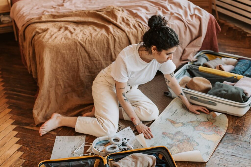 Travel Planning Tips — easier vacation planning tips Woman planning a trip with a map and suitcase — easier vacation planning tips