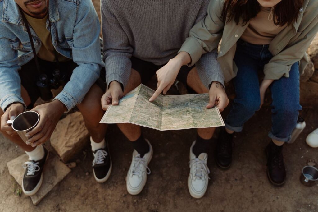 Planning a USA Cross-Country Road Trip Group planning a USA cross-country road trip using a map.