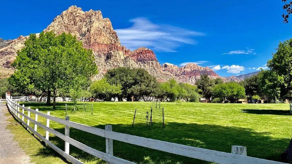 Red Rock Canyon, Nevada — hidden gems in the USA Red Rock Canyon landscape with sandstone cliffs and green grass — hidden gems in the USA