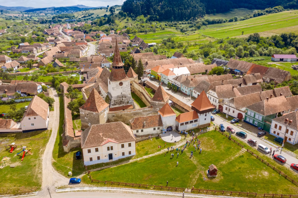 Romania's Fortified Churches — underrated countries to visit Aerial view of a fortified church and village in Romania. — underrated countries to visit