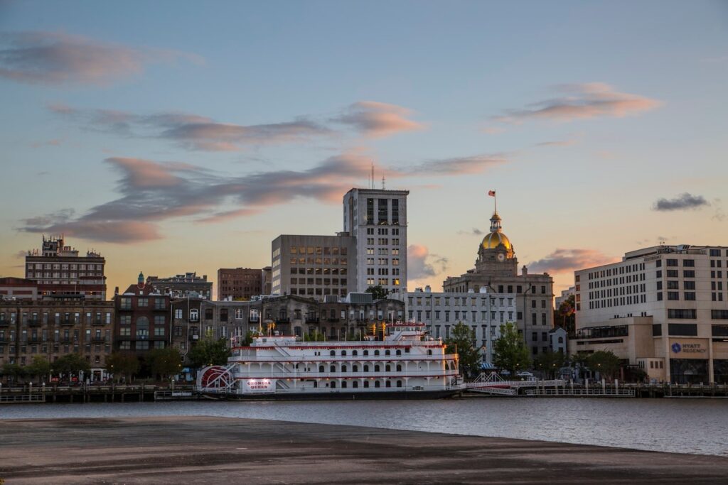 Savannah, Georgia Skyline — cheap places to travel in USA Savannah, Georgia skyline with historic buildings and a riverboat — cheap places to travel in USA