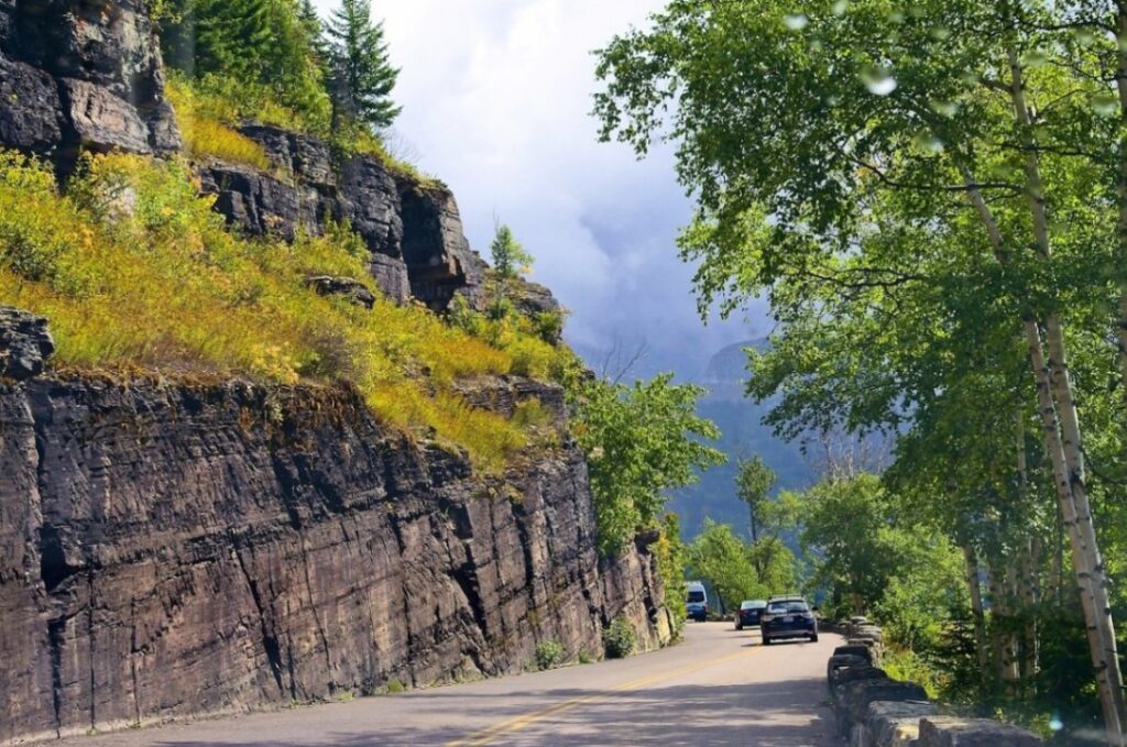 Scenic Road in Glacier National Park — RV USA road trip routes Scenic road through Glacier National Park with lush greenery and rocky cliffs — RV USA road trip routes