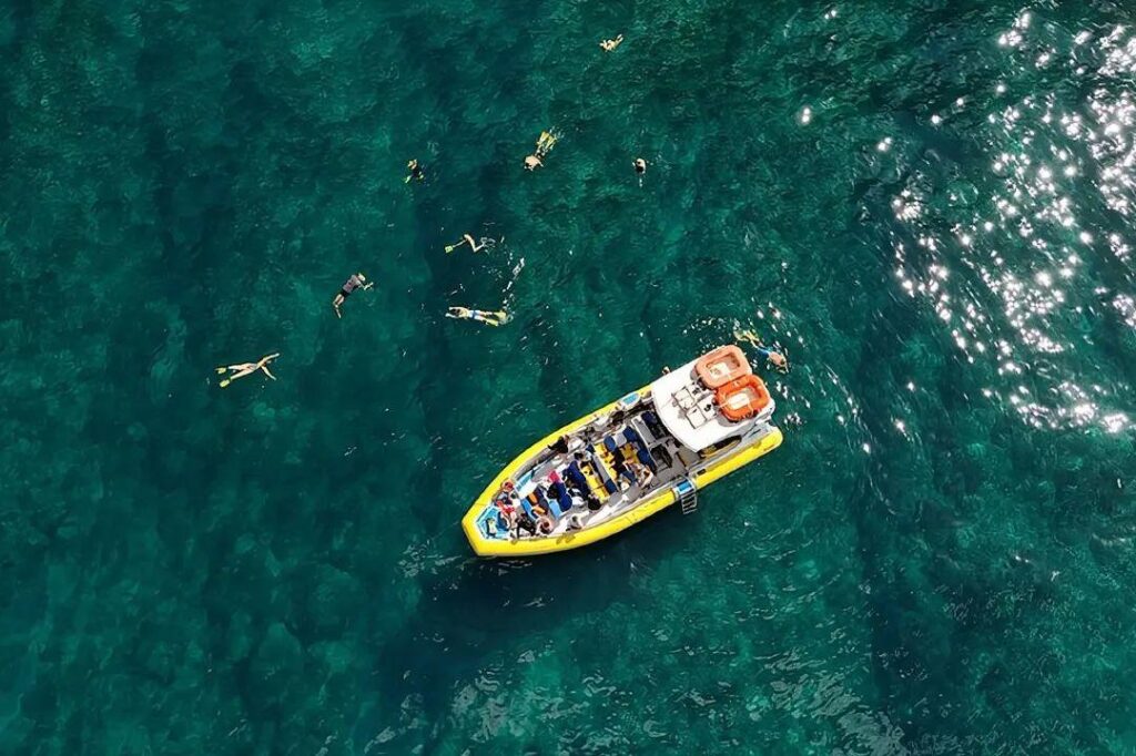 Snorkeling Adventure in Tropical Waters — unique travel destinations in the USA Snorkelers exploring clear waters near a boat in a tropical location. — unique travel destinations in the USA