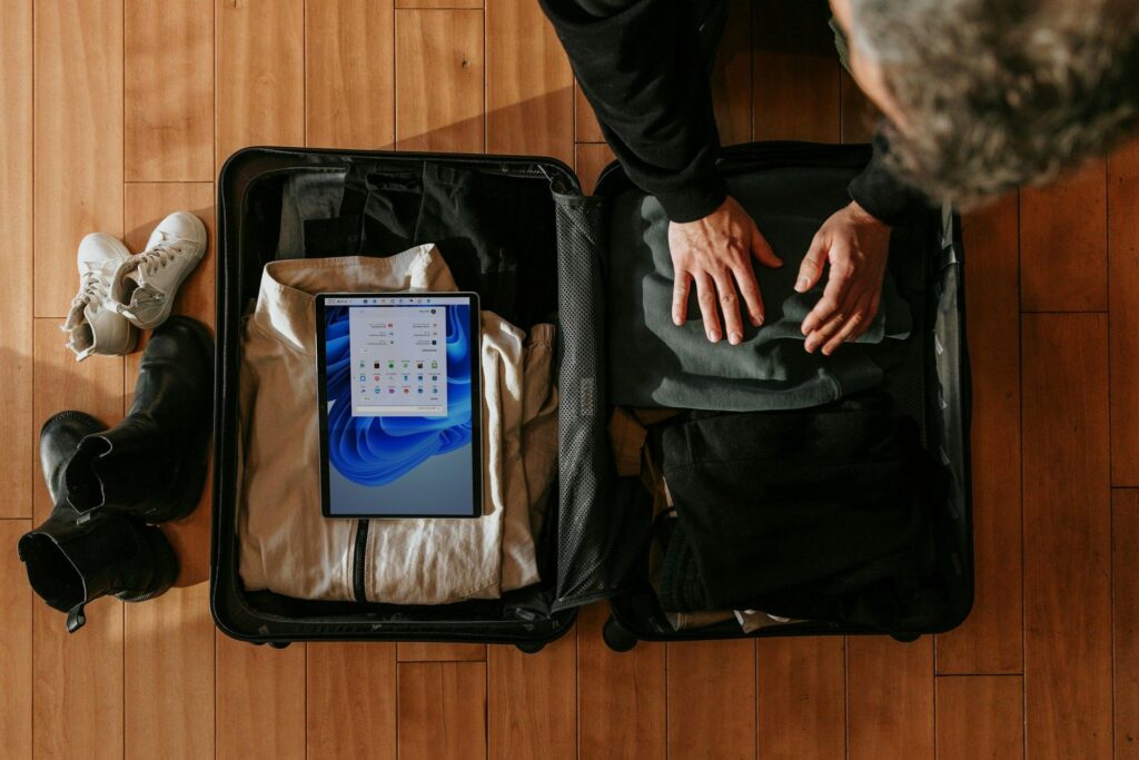 Solo Travel Packing Tips — Solo Travel Safety Tips Solo travel packing system with clothing and tablet in suitcase. — Solo Travel Safety Tips