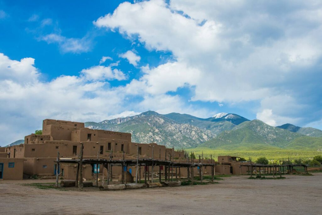 Taos, New Mexico Landscape — charming small towns in the USA Historic adobe buildings with mountains in the background in Taos, New Mexico. — charming small towns in the USA