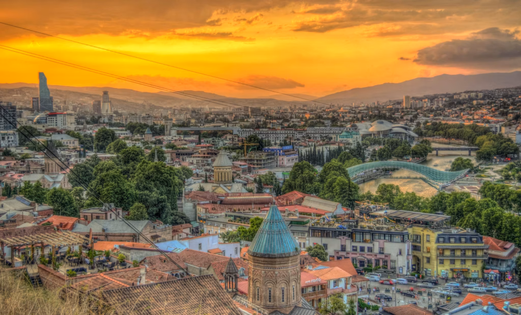 Tbilisi, Georgia at Sunset — underrated countries to visit A panoramic view of Tbilisi, Georgia at sunset, showcasing the city's architecture and — underrated countries to visit