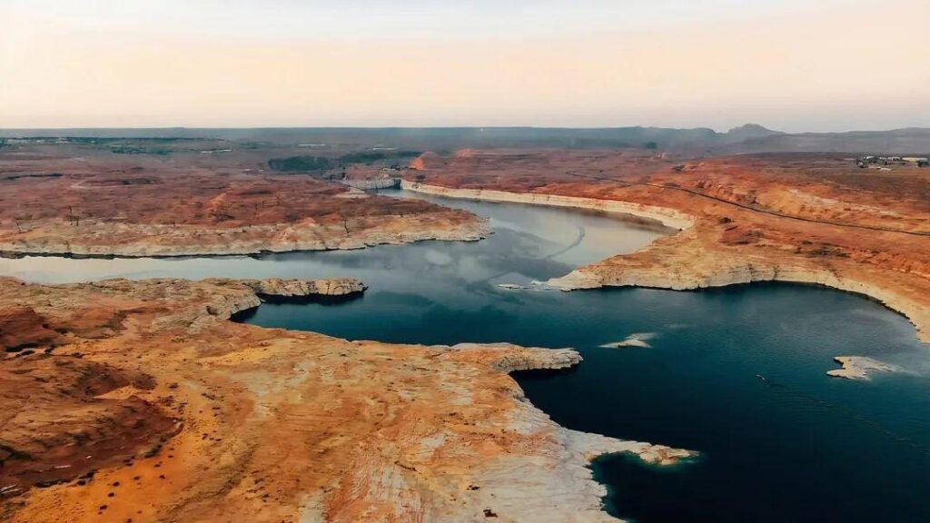 Winding River in Arizona — unique travel destinations in the USA Aerial view of a winding river surrounded by red rock formations and sandy shores in — unique travel destinations in the USA