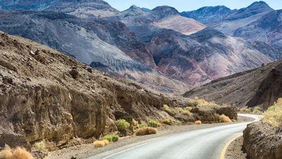 Winding Road in Death Valley — unique travel destinations in the USA Winding road through arid mountains in Death Valley National Park, showcasing unique travel destinations in the USA.