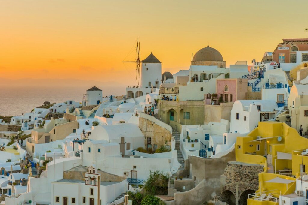 Santorini Sunset — beautiful getaways in Europe Beautiful sunset over the whitewashed buildings of Santorini, Greece. — beautiful getaways in Europe
