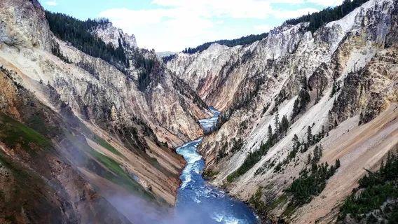 Yellowstone Canyon View — unique travel destinations in the USA A winding river flows through steep, colorful canyon walls in Yellowstone National — unique travel destinations in the USA