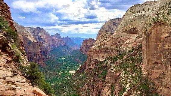 Zion Canyon Landscape — unique travel destinations in the USA Stunning view of Zion Canyon with steep rock formations and lush greenery below. — unique travel destinations in the USA