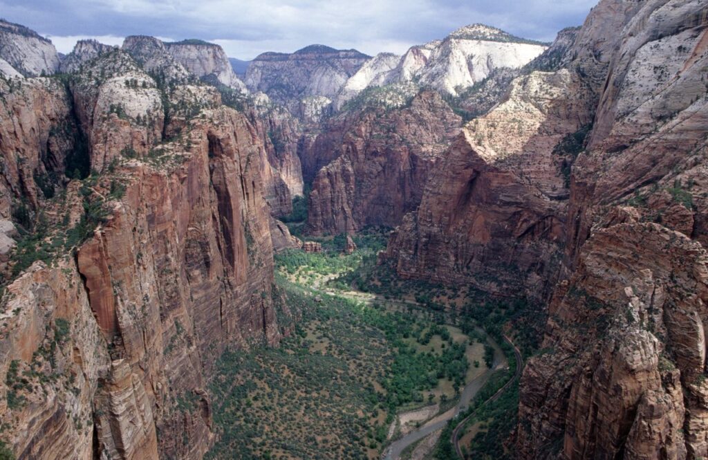 Zion Canyon View — beautiful places in America to visit Stunning view of Zion Canyon with red rock formations and a winding river below. — beautiful places in America to visit